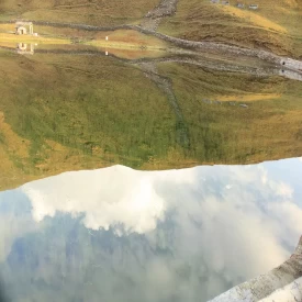 The crystal clear water of Bedini Kund perfectly reflect the Mountains and Clouds floating by..