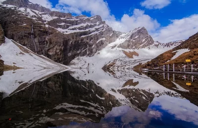 Reflection of snow covered mountains on Hemkund Lake at Hemkund sahib, Chamoli.