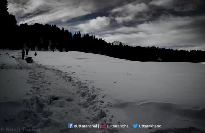 Trekkers finding their way to Kedarkantha summit and trek. You can see the footprints on snow covered land on this valley