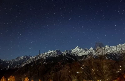 View of snow-capped Himalayan peaks shining under the Moon light as seen from Munsiyari.