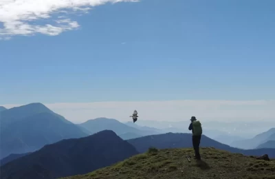 A tourist trying to capture the bird on his frame at Khaliya top, Munsiyari.
