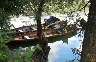 This photographs shows a corner of the beautiful Naini lake and the clear reflection of the sky with two boats.