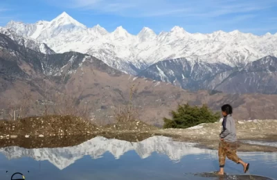 Kids in Munsiyari are playing in a rain water and they are trying to touch Panchachuli reflection in a water.
