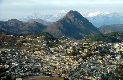 View of Pithoragarh city and snow capped Himalayan peaks in the background.