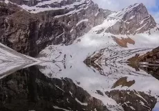Reflection of snow covered mountains on Hemkund Lake at Hemkund sahib, Chamoli.